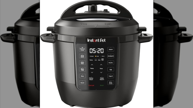 Someone stirring black beans cooking inside an Instant Pot