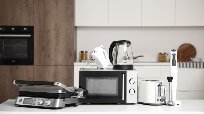 A variety of kitchen appliances sit atop a countertop