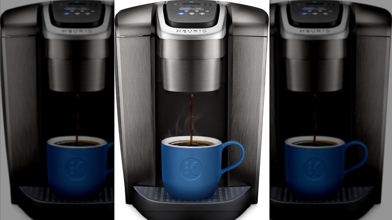 Silver and black Keurig K Cup coffee maker with a coffee cup