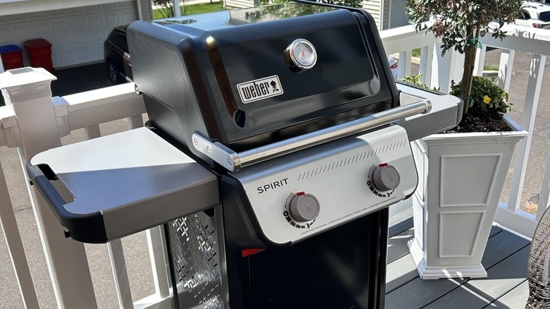 A Weber Spirit propane grill on a white porch