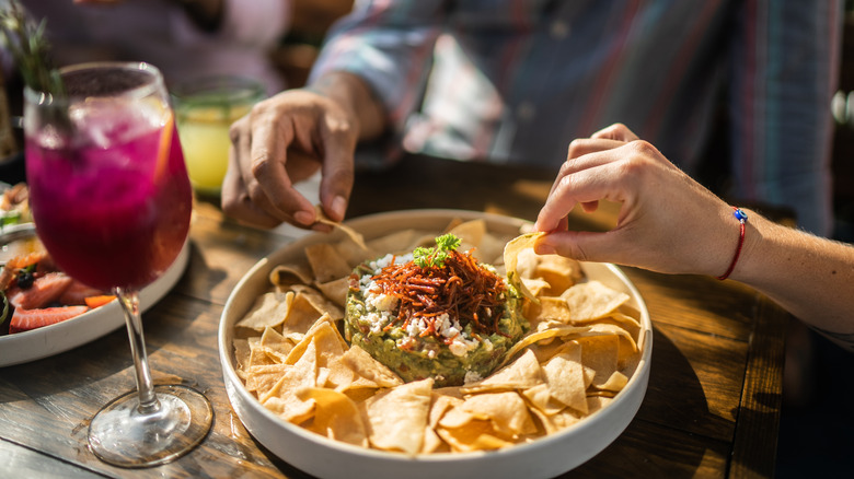 People eating guacamole in Tex Mex restaurant.