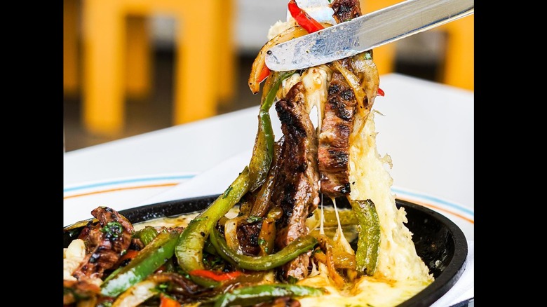 Pulling a cheese pull from the beef fajita plate at Joann's Fine Foods.