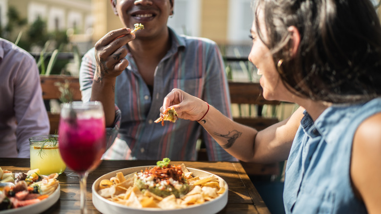 People eating guacamole in Tex Mex restaurant.