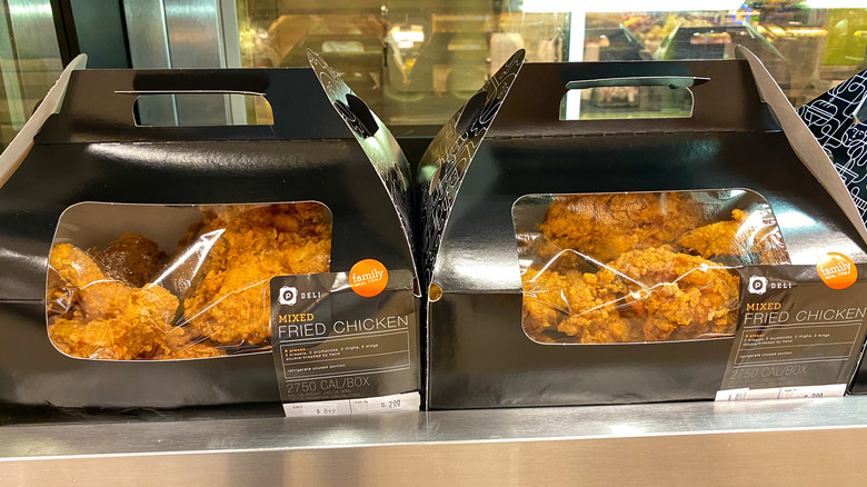 Two boxes of Publix mixed fried chicken on display in heated case in stores.