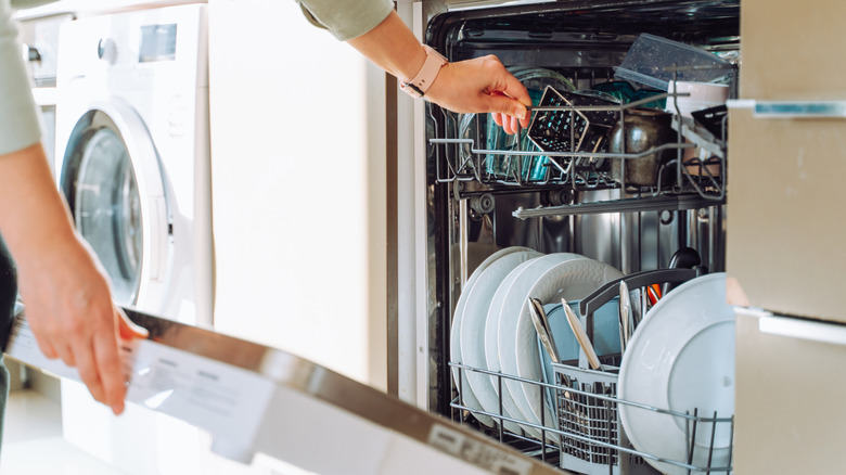 A person loading a dishwasher
