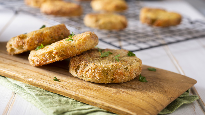 Freshly cooked fried green tomatoes on a wooden cutting board
