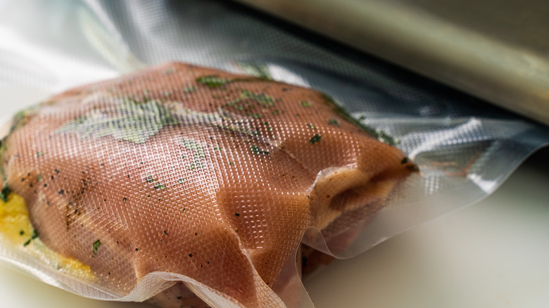 sealing chicken and herbs for sous vide