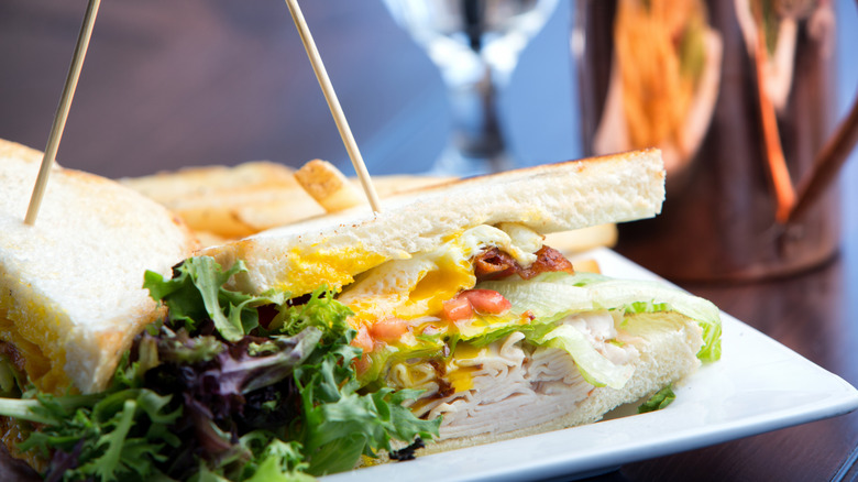a turkey and bacon sandwich held together by toothpicks