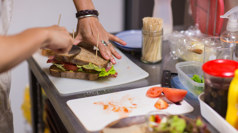 a woman preparing a veggie sandwich in the kitchen