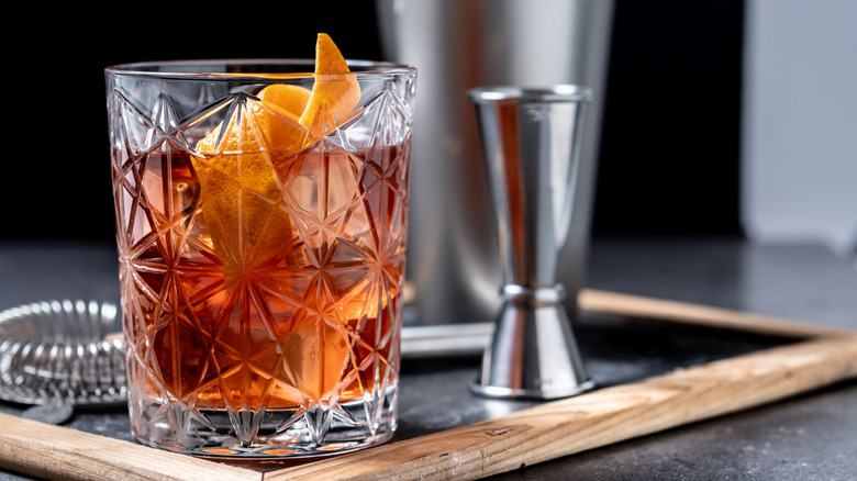 An old fashioned cocktail in a glass on a tray
