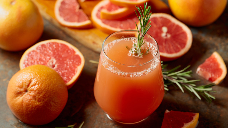 Rocks glass of grapefruit juice with a sprig of rosemary