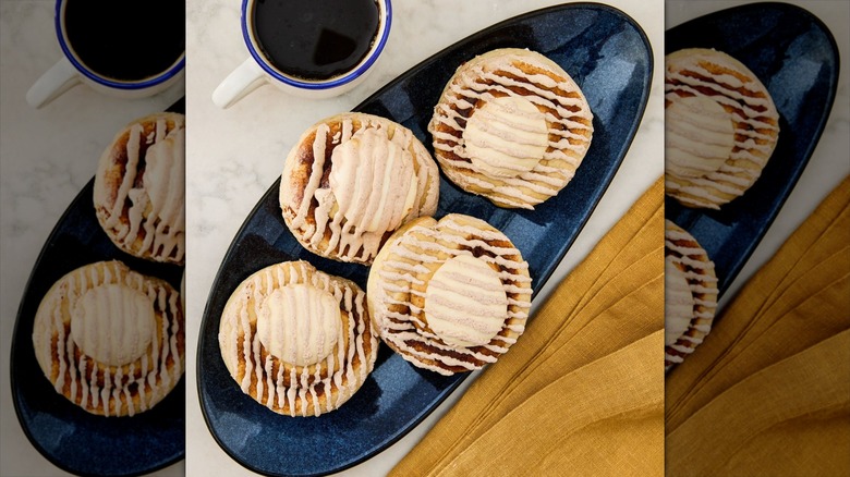 Marketside Baked Cinnamon Rolls in a black oval dish on a table next to a cup of coffee