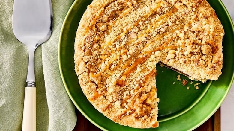 Walmart's 8-inch Caramel Apple Pie with one slice removed on a green plate.