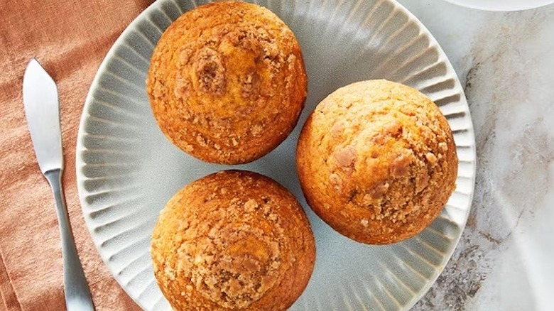 Three Pumpkin Spice Streusel Muffins sit on grey plate.