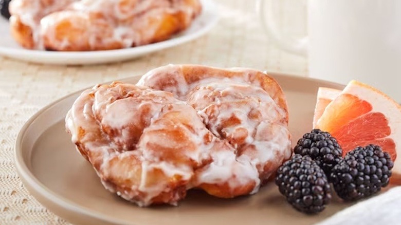 Whole apple fritters from Walmart served on a off-white plate.