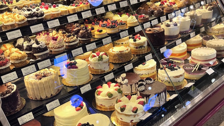 The bakery case at Whole Foods filled with cakes, tarts, and cupcakes
