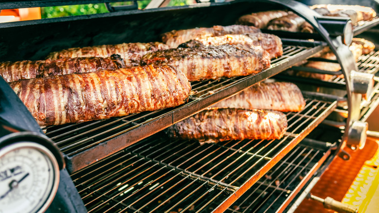 Several racks of meat inside a smoker