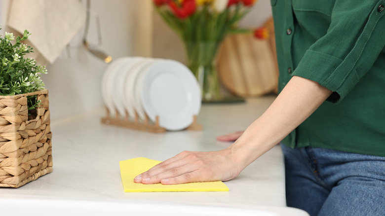 a hand cleaning stains off a white counter