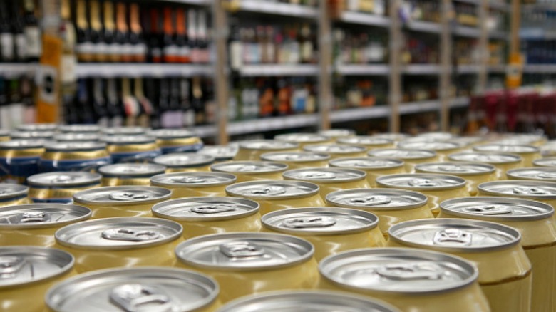 Cans of alcohol in front of wine bottles at a grocery store
