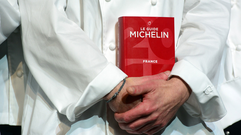 chef holding French Michelin Guide