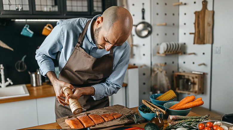 Man preparing fish in kitchen