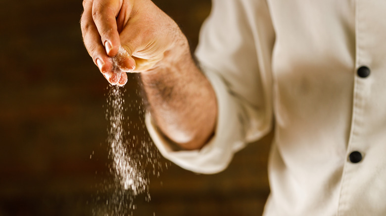 A hand seasoning food