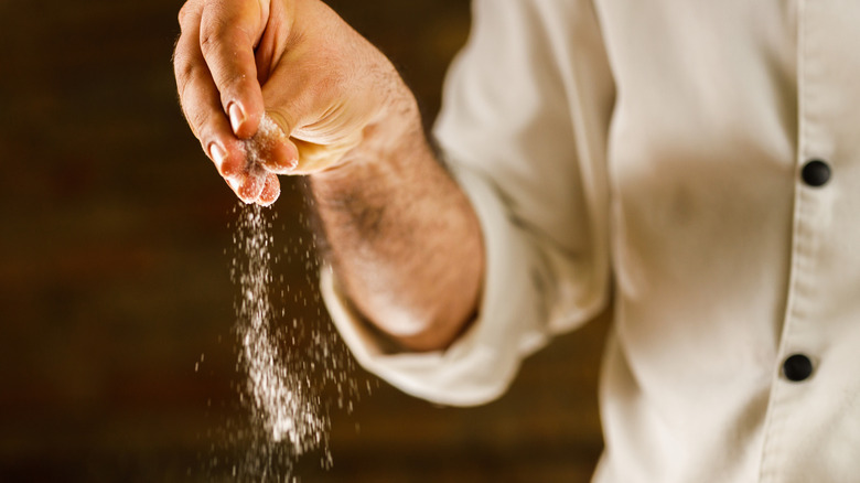 Chef adding salt