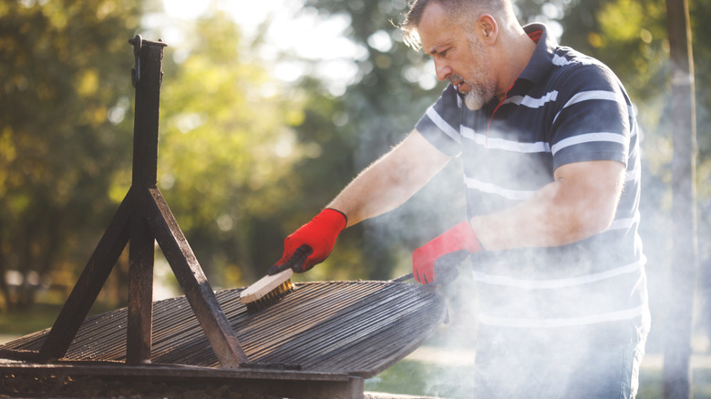 Man cleaning grill grates