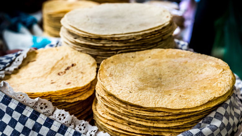 Three stacks of corn tortillas in a basket
