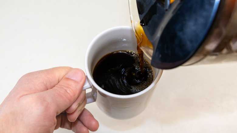 Pouring coffee into a mug.