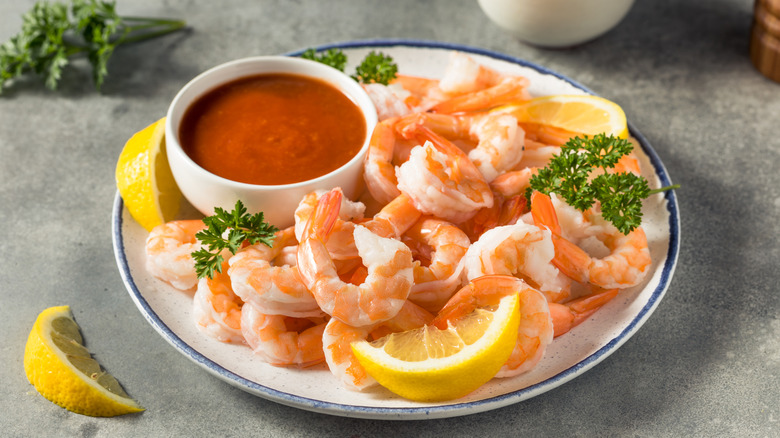 Plate of shrimp with a bowl of sauce.