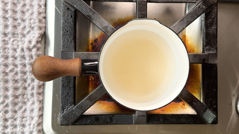 Water and sugar in saucepan on stovetop