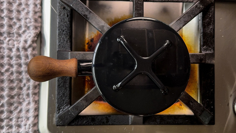 Black covered saucepan on stovetop