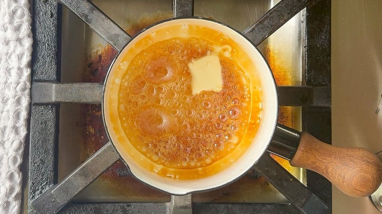 Caramelized sugar syrup and butter in saucepan on stovetop