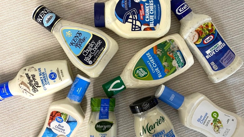 nine bottles of different blue cheese dressings flat on a table