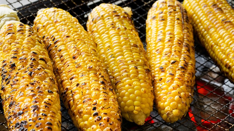 four pieces of corn on the cob on the grill