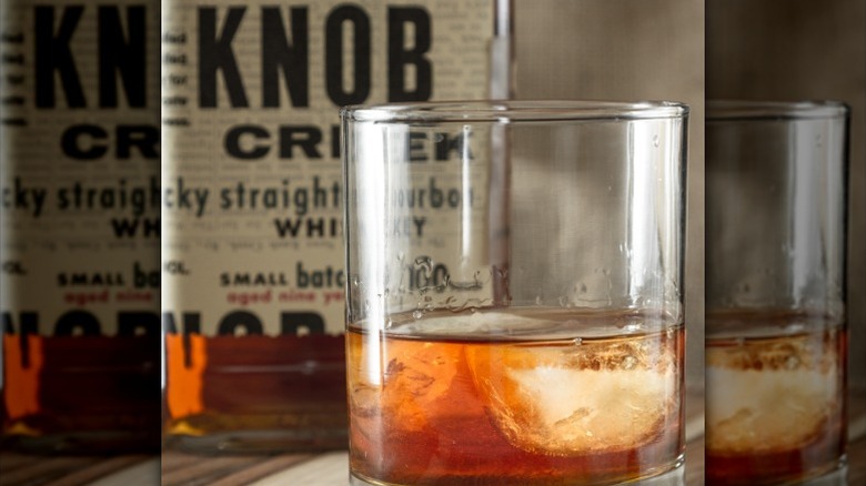 Glass of Knob Creek bourbon with bottle in bacground