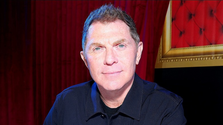 Bobby Flay half-smiling and wearing a dark blue button-down shirt