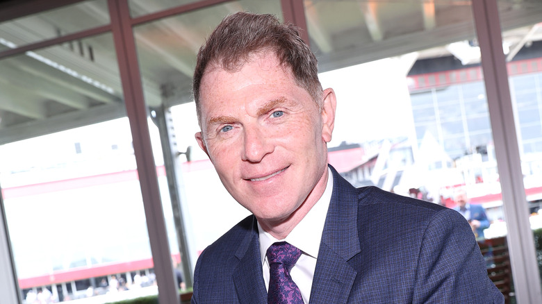 Bobby Flay smiling, wearing a suit and tie. 