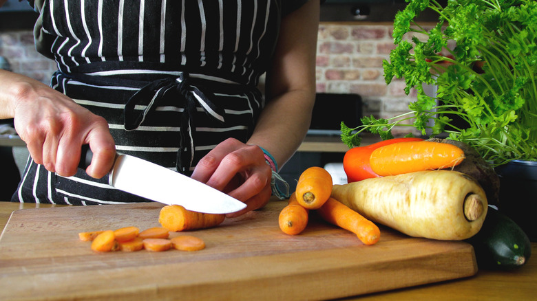 Hand using a chef's knife to cut