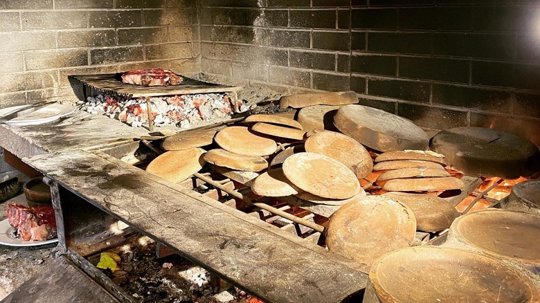 A steak cooking on a grill at Agriosteria Tenuta Astrone in Sarteano