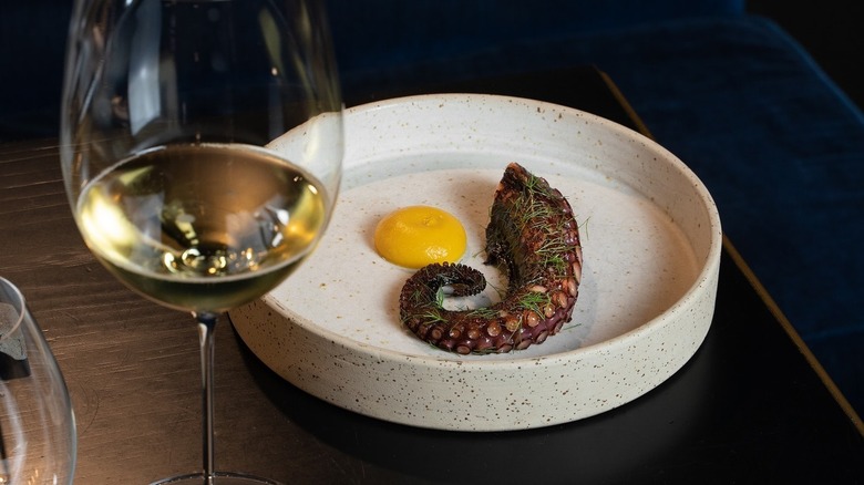 An octopus dish with a glass of wine at Da Francesco in Rome