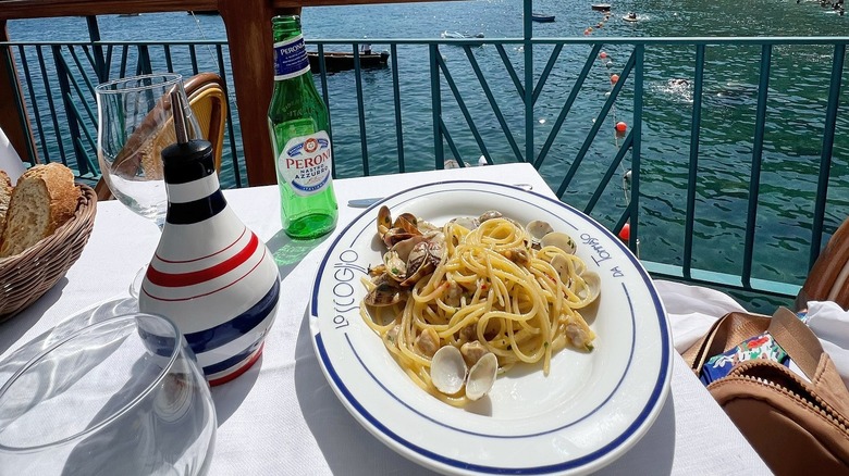 A plate of spaghetti vongole on a waterside table at Lo Scoglio on the Amalfi Coast