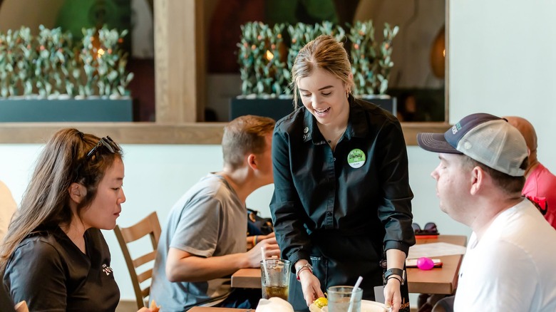 Waitress clearing plates from a table at Olive Garden