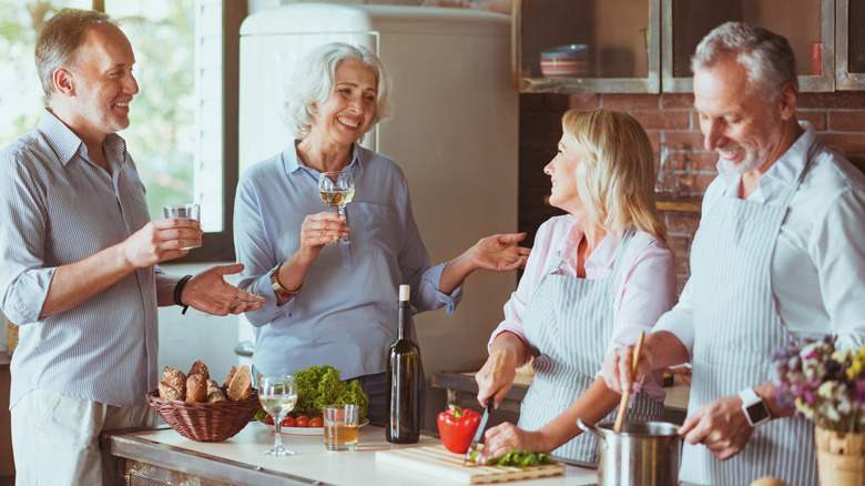 A group of older people preparing a meal in the kitchen