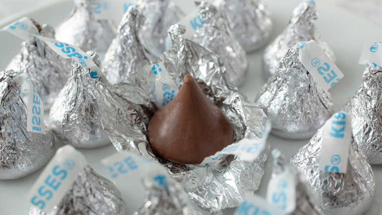 Several Hershey's Kisses with one unwrapped in the middle.