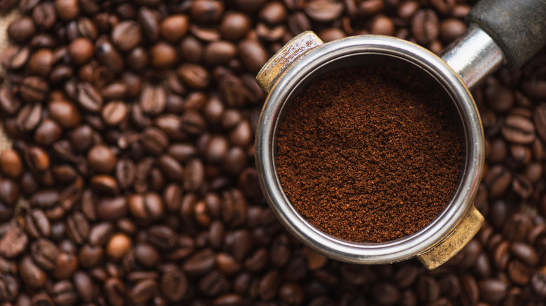 coffee beans with freshly ground coffee in a portafilter