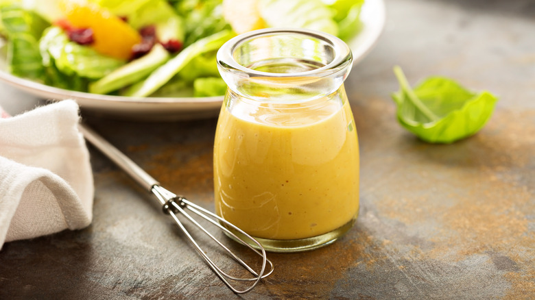 Vinaigrette salad dressing with a salad in the background
