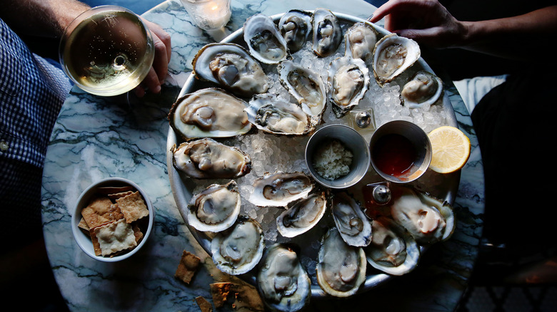 Large plate of raw oysters and champagne