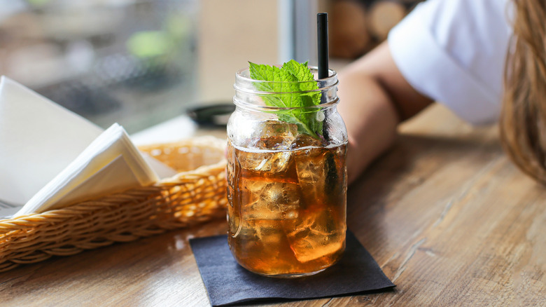 Iced tea in a glass mason jar garnished with mint.